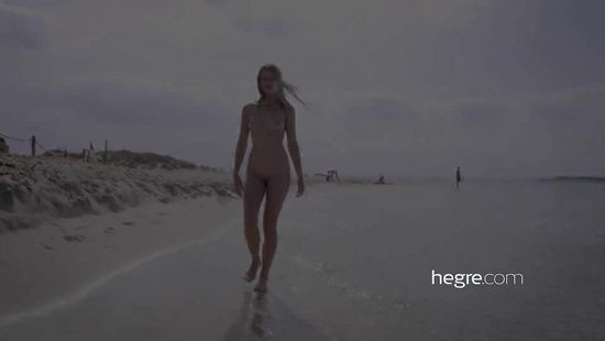 Молоденькая нудистка купается обнаженной в море и прогуливается по пляжу